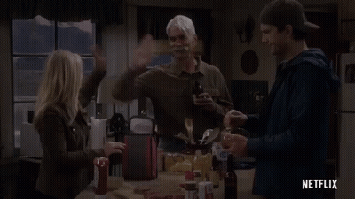 A Group Of People Are Standing Around A Table In A Kitchen With A Netflix Logo In The Corner . GIF