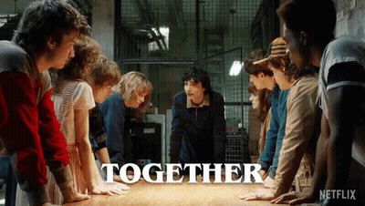 A Group Of People Are Standing Around A Table With The Word Together Written On It GIF