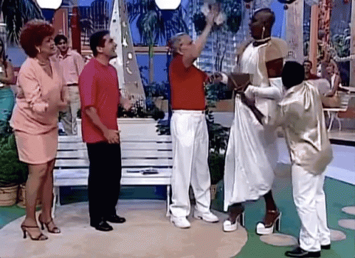 A Group Of People Are Standing Around A Woman In A Dress GIF