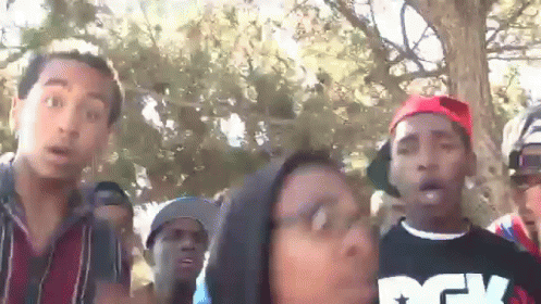 A Group Of People Are Standing Around A Woman Wearing A Shirt That Says Dgk On It GIF