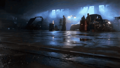 A Group Of People Are Standing In A Dark Garage GIF