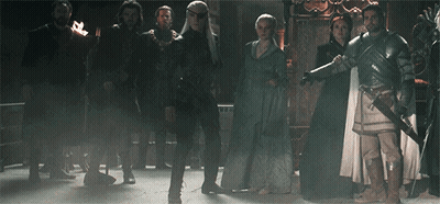 A Group Of People Are Standing In A Dark Room . GIF