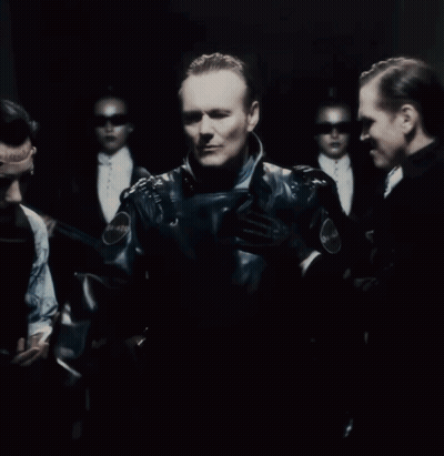 A Group Of People Are Standing In A Dark Room With A Sign On The Wall That Says Emergency GIF