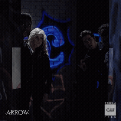 A Group Of People Are Standing In A Dark Room With Arrow Written On The Bottom GIF
