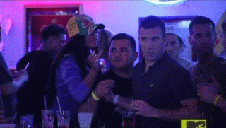 A Group Of People Are Standing In A Dark Room With Purple Lights . GIF