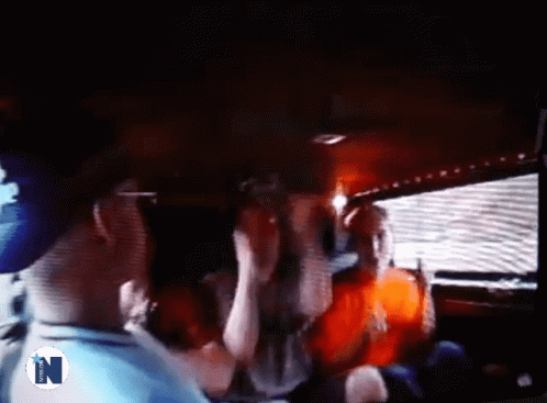 A Group Of People Are Standing In A Dark Room With The Letter N On The Bottom Right GIF