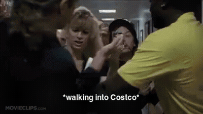 A Group Of People Are Standing In A Hallway Talking To Each Other . GIF