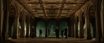 A Group Of People Are Standing In A Hallway With Arches GIF