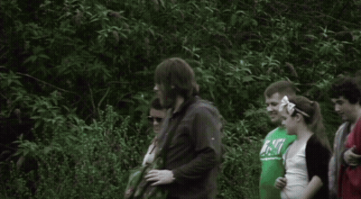 A Group Of People Are Standing In A Line And One Of Them Is Wearing A Shirt That Says ' Abercrombie ' On It GIF