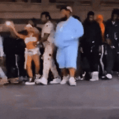 A Group Of People Are Standing In A Line . GIF