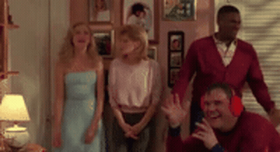 A Group Of People Are Standing In A Living Room . GIF