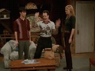 A Group Of People Are Standing In A Living Room And One Of Them Is Wearing A Shirt That Says ' I Love You ' GIF