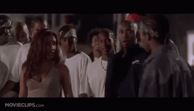 A Group Of People Are Standing In A Room And A Woman Is Standing In The Middle Of The Room . GIF