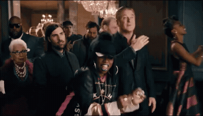 A Group Of People Are Standing In A Room And Dancing . GIF