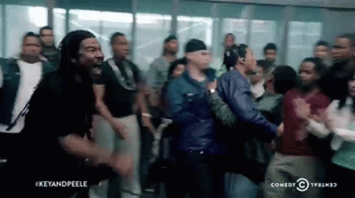 A Group Of People Are Standing In A Room And Having A Fight . GIF