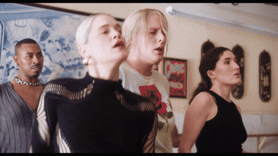 A Group Of People Are Standing In A Room And One Of Them Has A T-Shirt That Says " I Love You " GIF