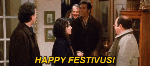 A Group Of People Are Standing In A Room And One Of Them Is Saying Happy Festivus ! GIF