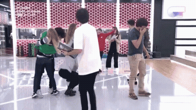 A Group Of People Are Standing In A Room And One Of Them Is Wearing A Shirt That Says ' Coco ' On The Back GIF