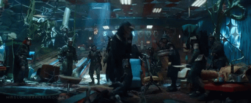 A Group Of People Are Standing In A Room . GIF