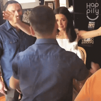 A Group Of People Are Standing In A Room With A Sign That Says Hap Pillu GIF