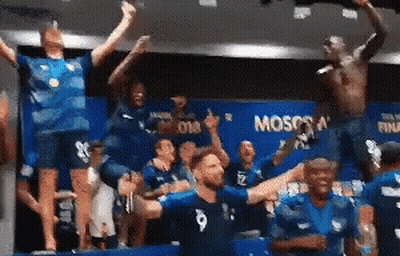 A Group Of People Are Standing In A Room With The Word Moscow On The Wall . GIF