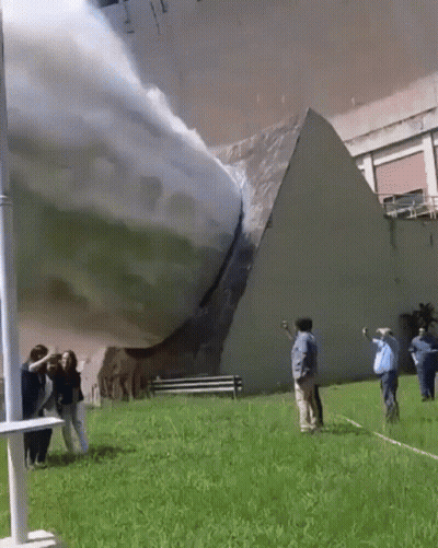 A Group Of People Are Standing In Front Of A Building That Has A Pyramid On It GIF