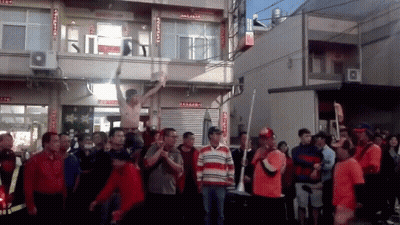 A Group Of People Are Standing In Front Of A Building With Chinese Writing On The Side GIF