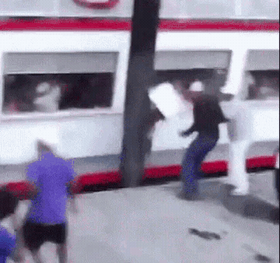 A Group Of People Are Standing In Front Of A Bus . GIF