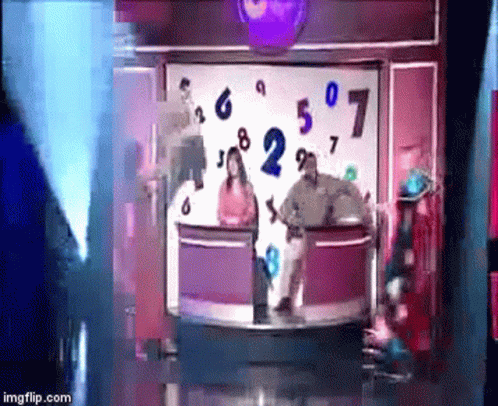 A Group Of People Are Standing In Front Of A Display Of Numbers GIF