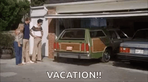 A Group Of People Are Standing In Front Of A Garage With A Green Woody Station Wagon In It . GIF