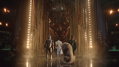A Group Of People Are Standing In Front Of A Large Sculpture GIF