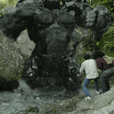 A Group Of People Are Standing In Front Of A Large Statue GIF