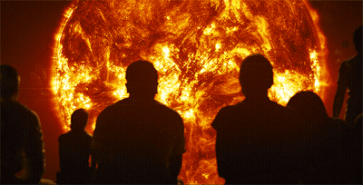 A Group Of People Are Standing In Front Of A Large Sun GIF