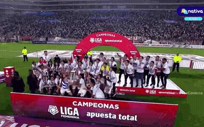 A Group Of People Are Standing In Front Of A Podium That Says Campeonas Liga Apuesta Total GIF