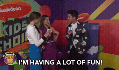 A Group Of People Are Standing In Front Of A Sign That Says Kids Choice GIF