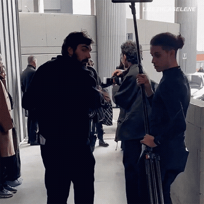 A Group Of People Are Standing In Front Of A Sign That Says Lizeth La Selene GIF