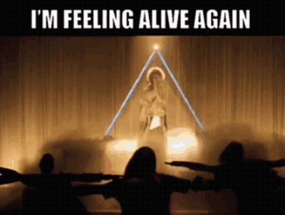 a group of people are standing in front of a stage with the words i 'm feeling alive again