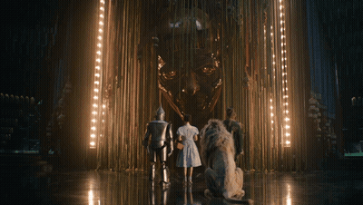 A Group Of People Are Standing In Front Of A Statue GIF