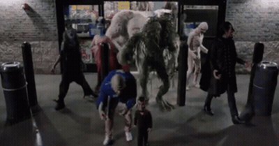 A Group Of People Are Standing In Front Of A Store With Monsters Coming Out Of The Door . GIF