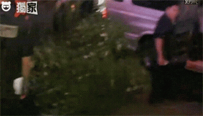 A Group Of People Are Standing In Front Of A Van And Talking To Each Other . GIF