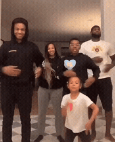 A Group Of People Are Standing Next To Each Other Dancing . GIF
