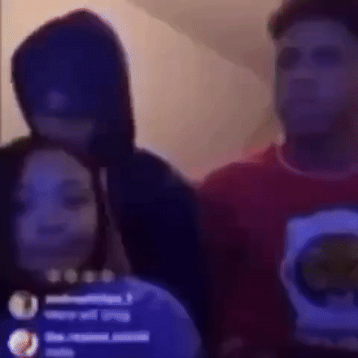 A Group Of People Are Standing Next To Each Other In A Dark Room . One Of The People Is Wearing A Hoodie . GIF