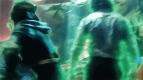 A Group Of People Are Standing Next To Each Other In A Dark Room With Green Lights Coming Out Of Their Bodies . GIF