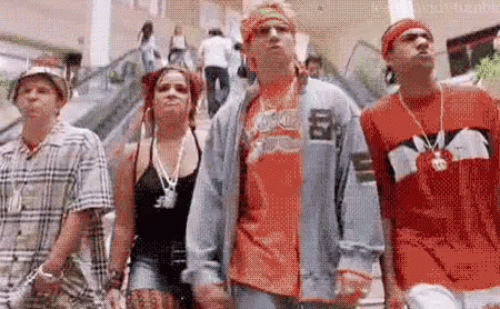 A Group Of People Are Standing Next To Each Other In A Mall . GIF