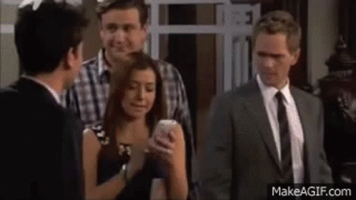 A Group Of People Are Standing Next To Each Other In A Room . GIF