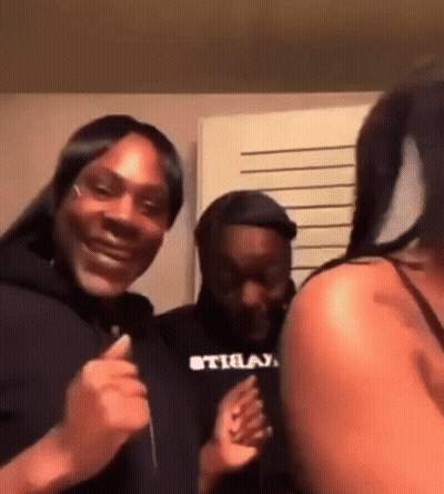 A Group Of People Are Standing Next To Each Other In A Room And Laughing . GIF