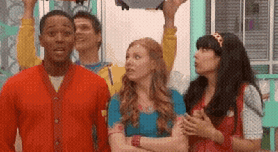 A Group Of People Are Standing Next To Each Other In A Room And One Of Them Is Holding Something In His Hand . GIF