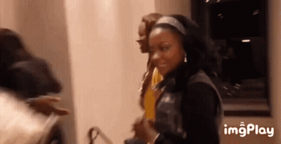 A Group Of People Are Standing Next To Each Other In A Room And Smiling . GIF