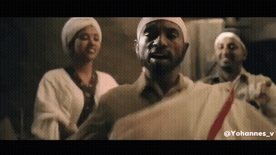 A Group Of People Are Standing Next To Each Other In A Room . One Of The Men Is Wearing A White Turban . GIF