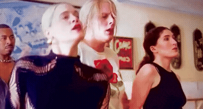 A Group Of People Are Standing Next To Each Other In A Room With A Sign That Says Come On . GIF